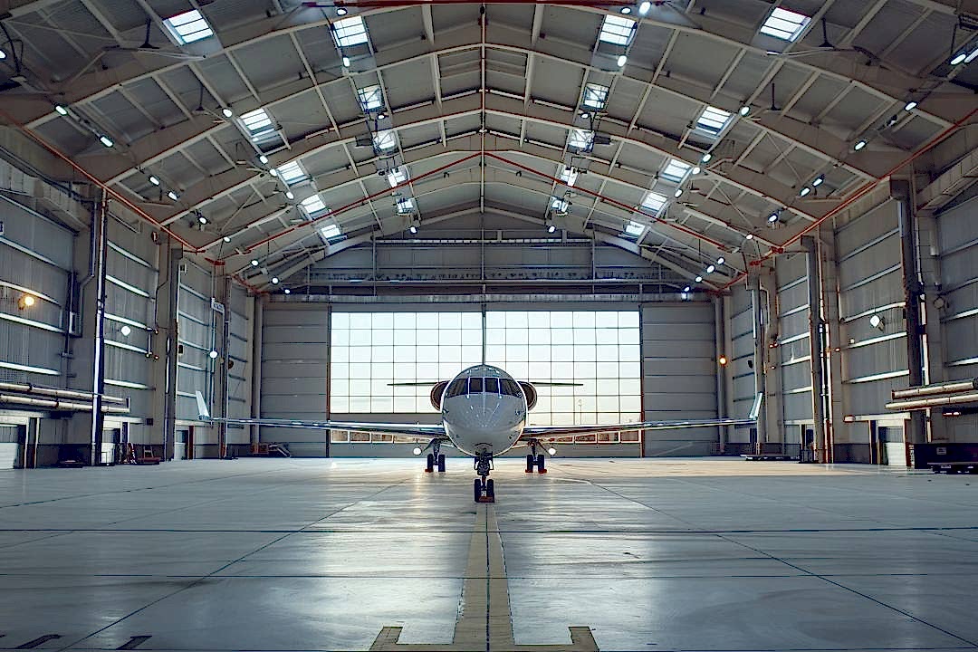 Hangar ortamında uygulanan endüstriyel zemin kaplama türlerini gösteren epoksi zeminli uçak hangarı